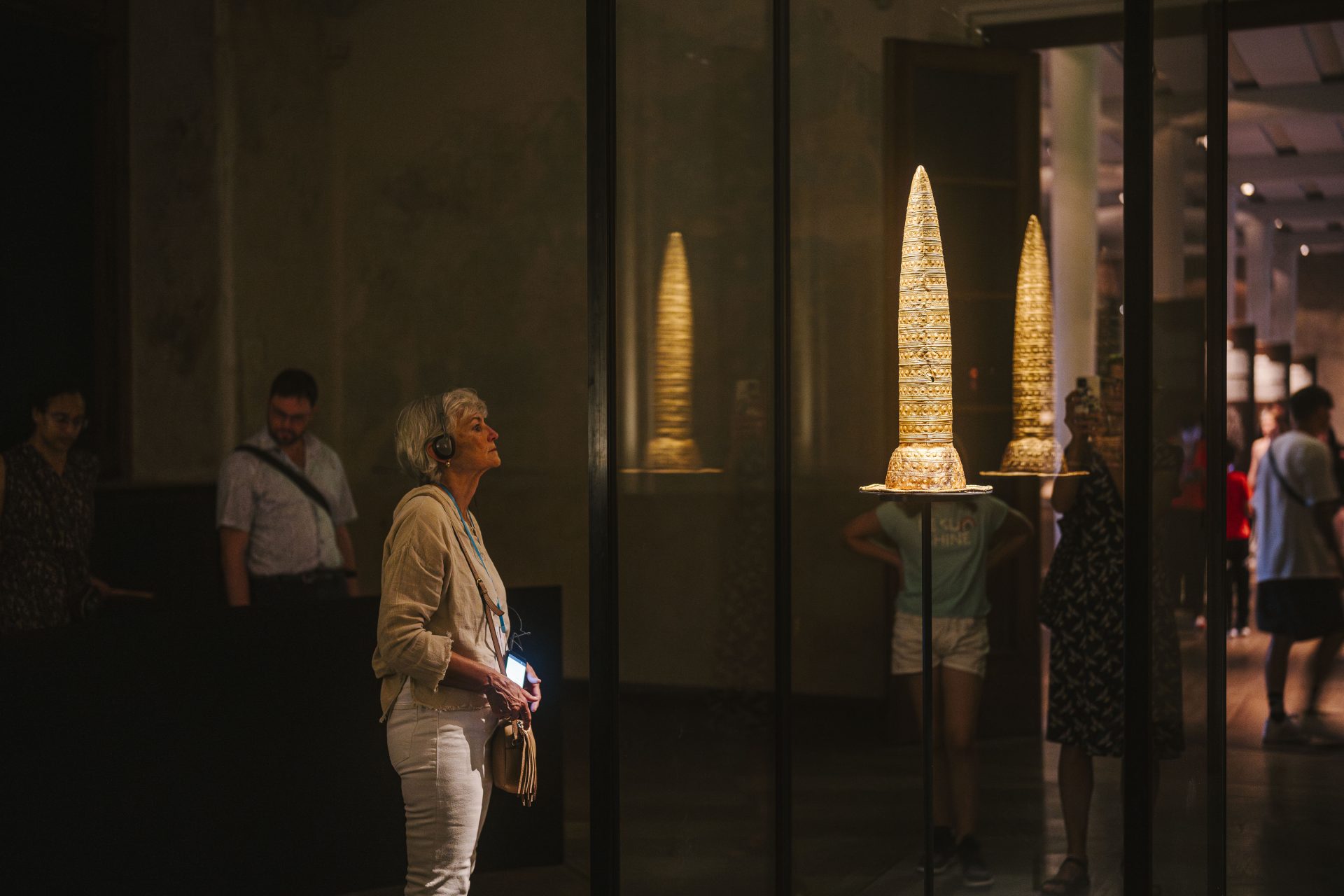 A visitor with an audio guide looks at the Berlin Gold Hat in the Neues Museum