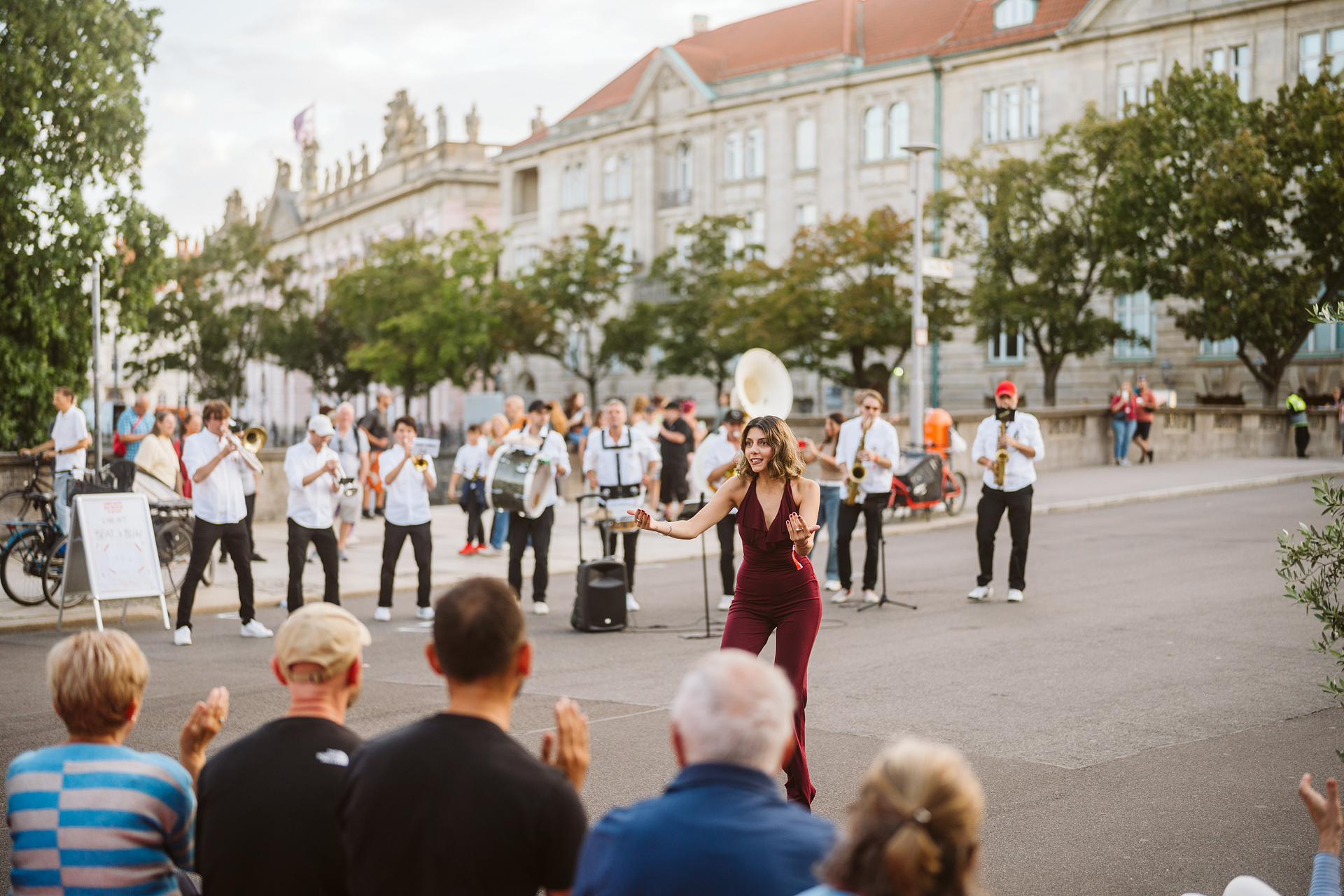 Street performance with a singer and band before an audience in an urban setting.