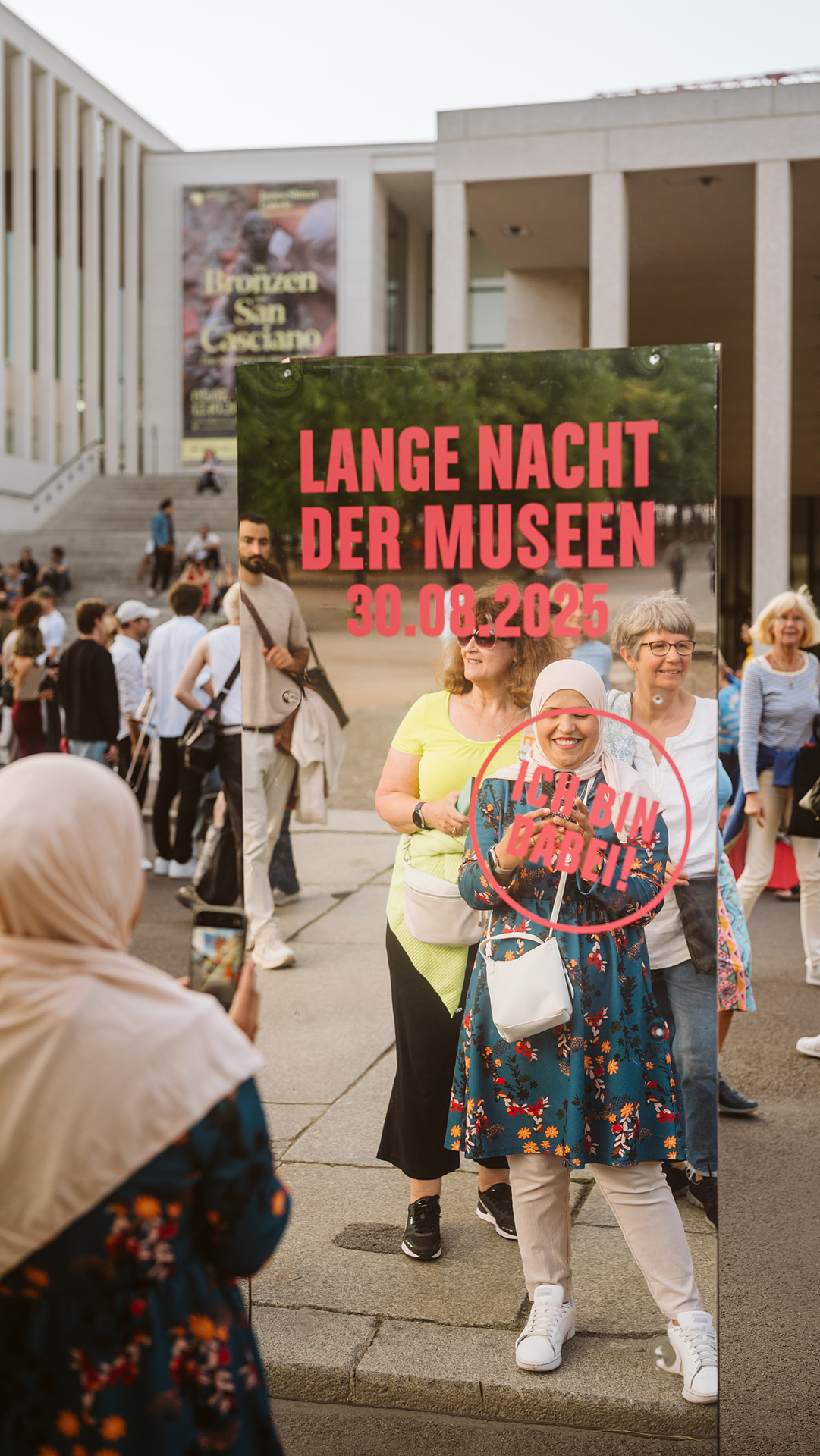 A group of people holds a poster for the "Long Night of Museums" on August 30, 2025. Happy atmosphere.